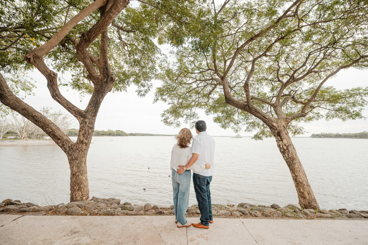 Couple under trees by the water